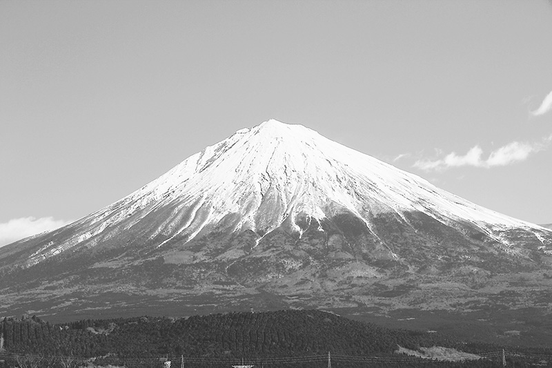 雪を頂いた富士山の山頂と裾野を望む風景の写真