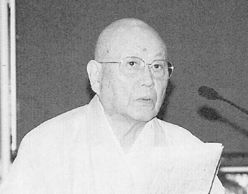 法衣をまとい、眼鏡をかけた年配男性の白黒肖像写真